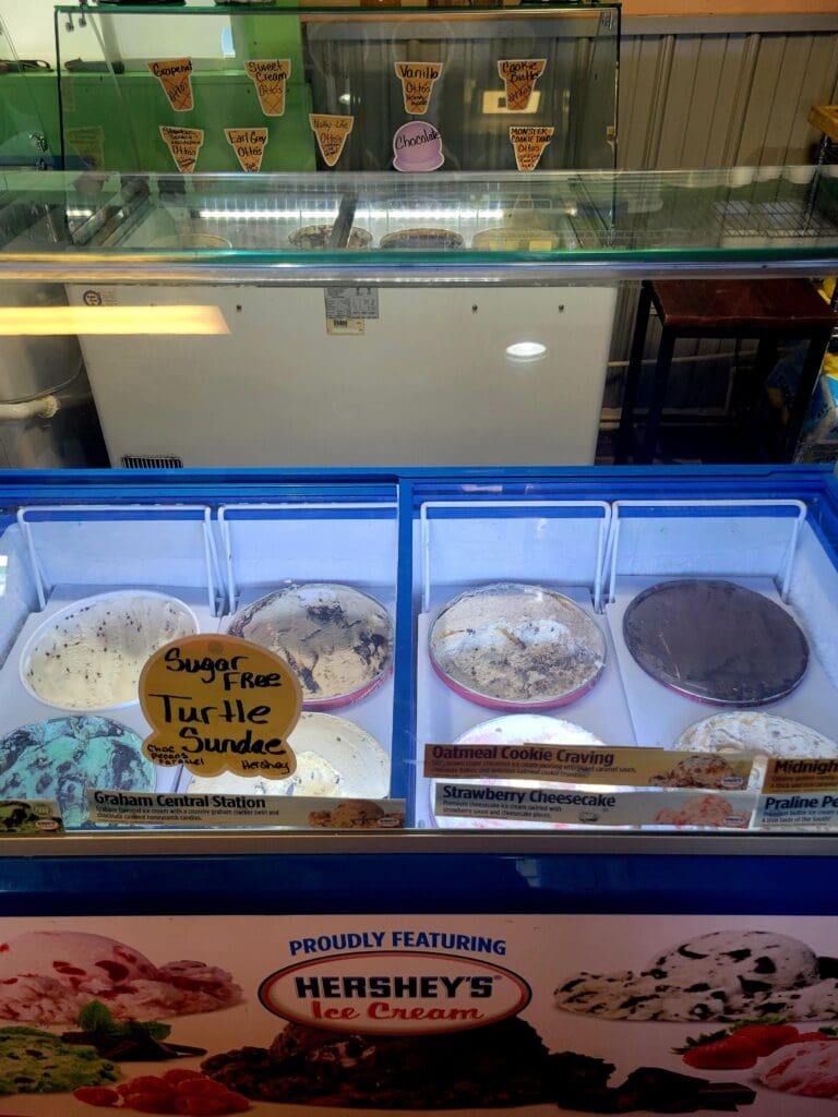 A Hershey's branded ice cream or dessert display case with multiple sample containers arranged in blue bins at a retail counter.