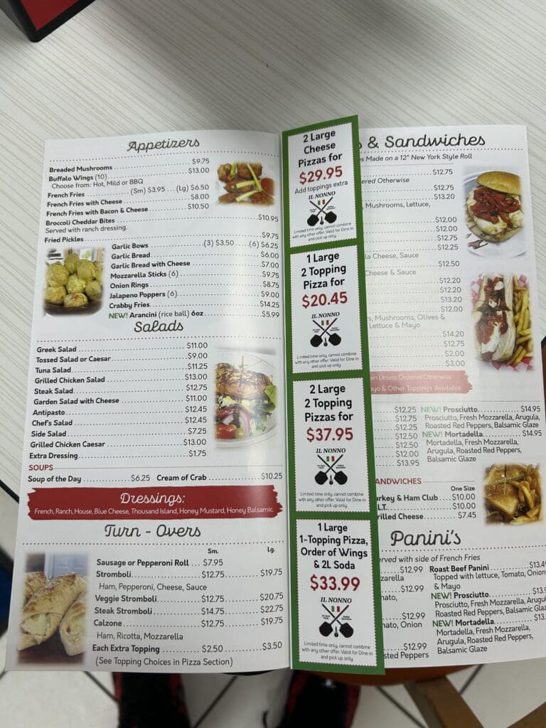 An overhead view of an open restaurant menu displaying various sandwich options, appetizers, and beverages with food photographs and descriptions.