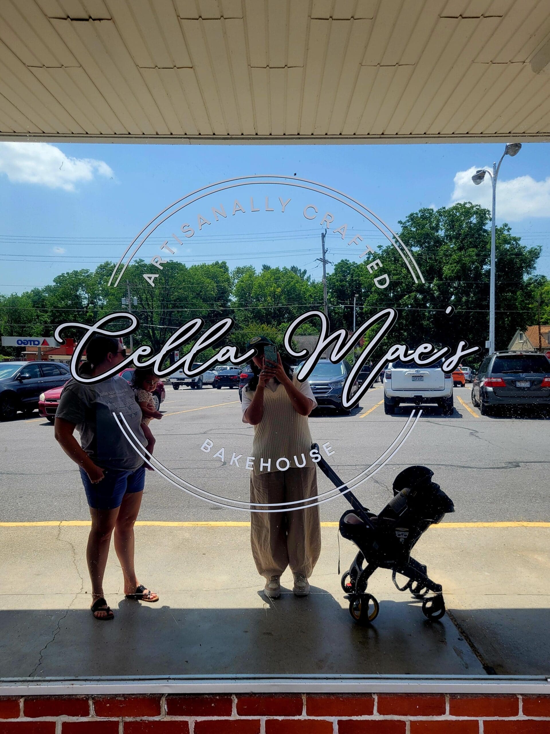 Three pageant contestants pose outdoors with a black poodle in front of a storefront with 'Bella Viper' signage visible on the window.