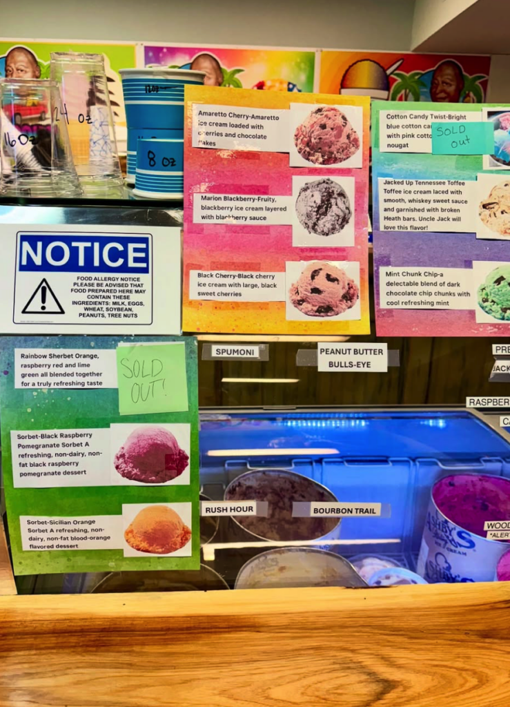 A colorful educational display board with informational posters, notices, and images of various food items and produce mounted on a wall.