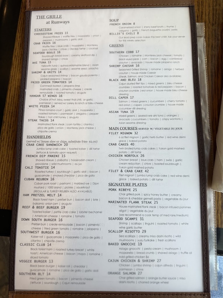 A restaurant menu page photographed from above, displaying multiple food items and descriptions in a two-column layout on aged, slightly discolored paper.