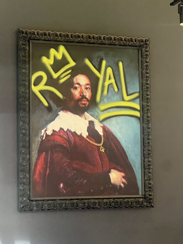 A classical portrait of a regal figure in a ornate frame is overlaid with bright yellow and red neon text reading 'ROYAL'.