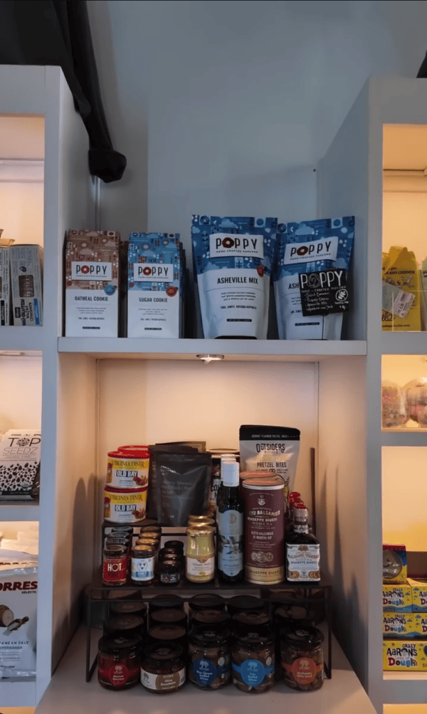 A well-organized kitchen pantry with illuminated shelves displaying neatly arranged canned goods, jars, and food storage containers.