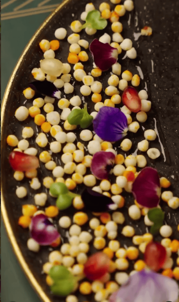 An overhead view of a decorative bowl filled with colorful assorted candies in vibrant shades of yellow, purple, red, green, and white.