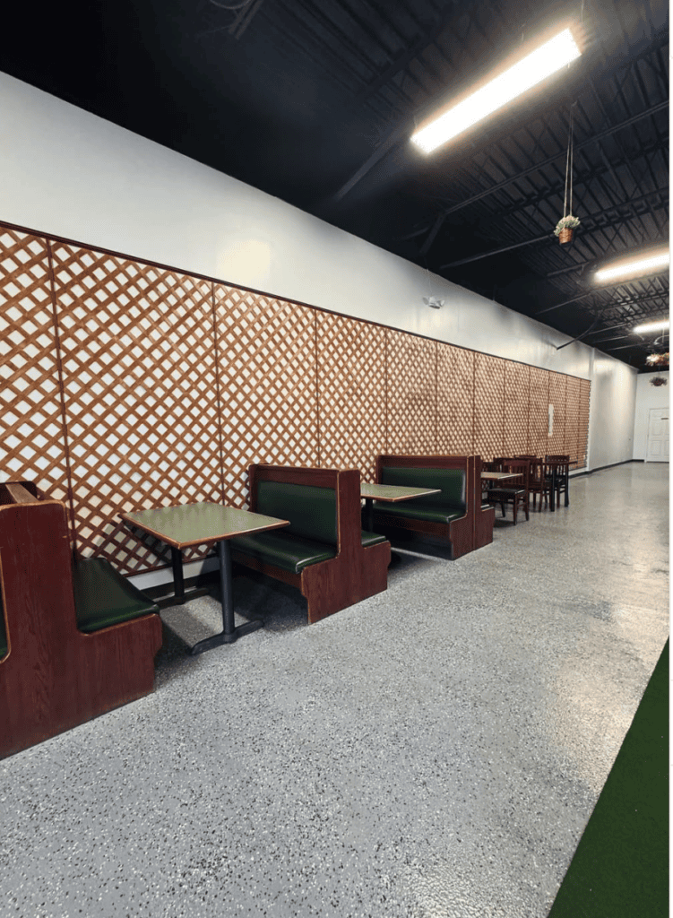 A modern workshop or creative studio interior featuring contemporary seating, geometric wall paneling, and industrial ceiling lighting.