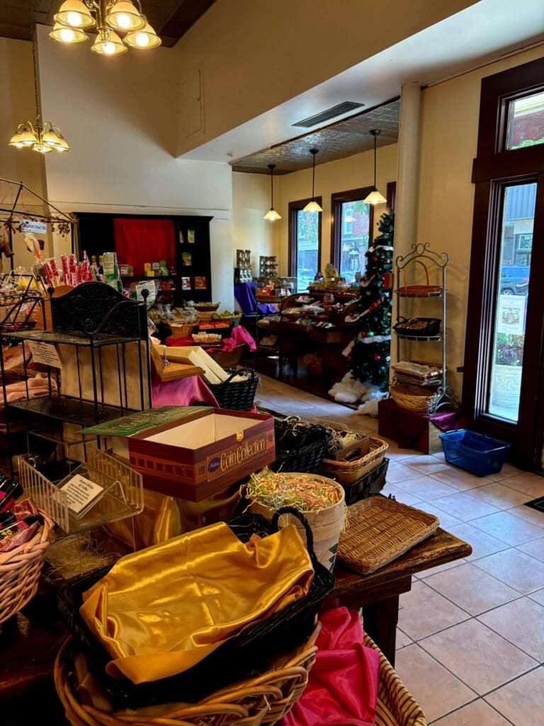 A bright, organized workshop or studio space filled with craft supplies, a prominent yellow canoe, wooden furniture, and various storage solutions bathed in natural daylight.