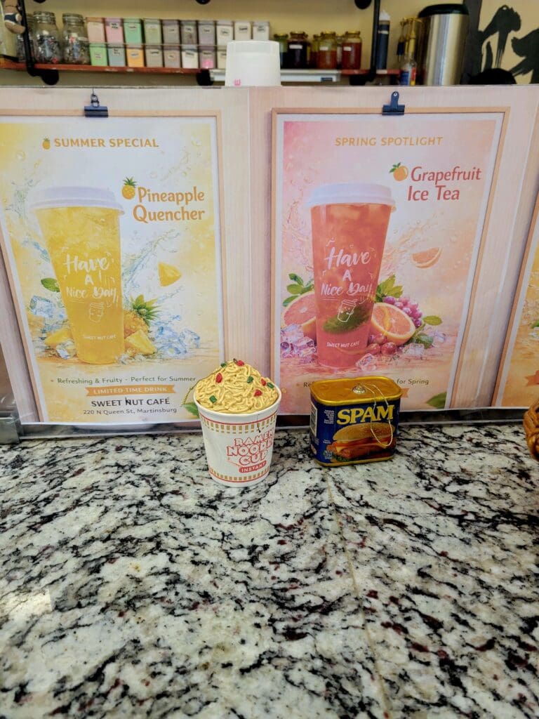 Two tea product boxes with floral designs displayed on a granite countertop alongside a decorative cup in a kitchen setting.