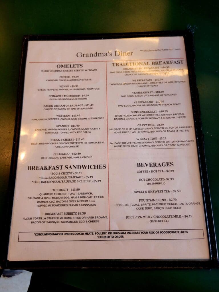 A restaurant menu board displaying breakfast sandwiches and beverages with a beige and brown color scheme.