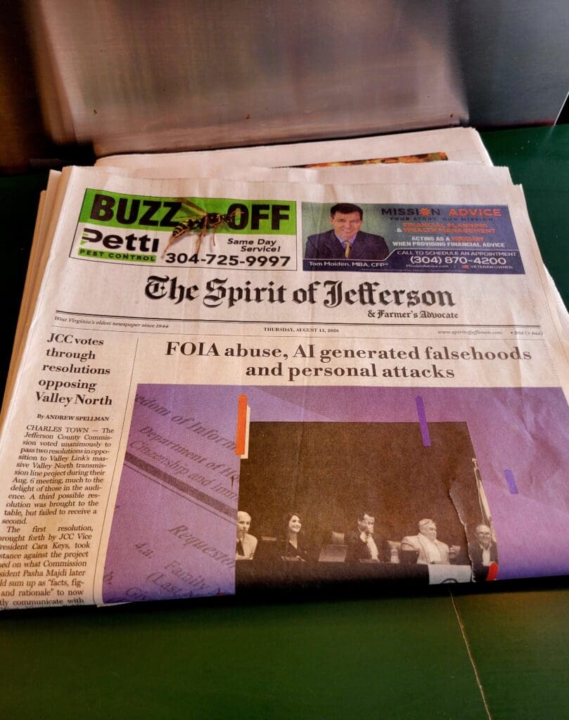 A close-up photograph of a newspaper with visible headlines and a large photograph showing what appears to be an indoor event or gathering.