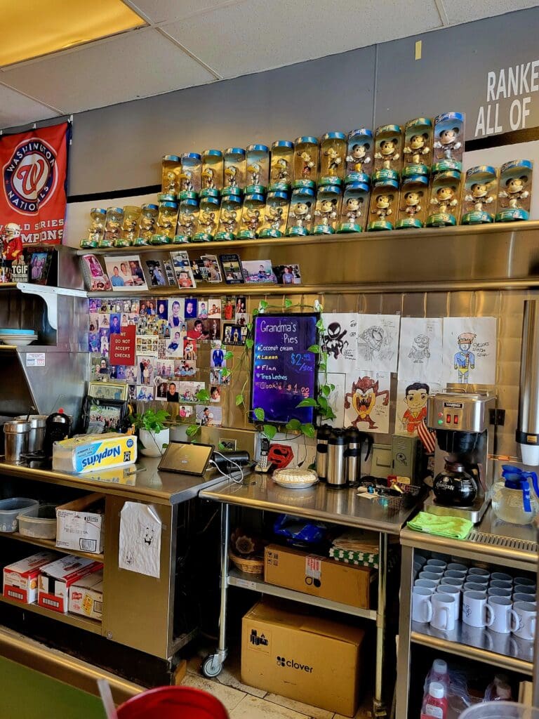 An organized workshop or retail display area featuring shelves stocked with yellow containers, educational materials, and various supplies arranged on walls and counter surfaces.