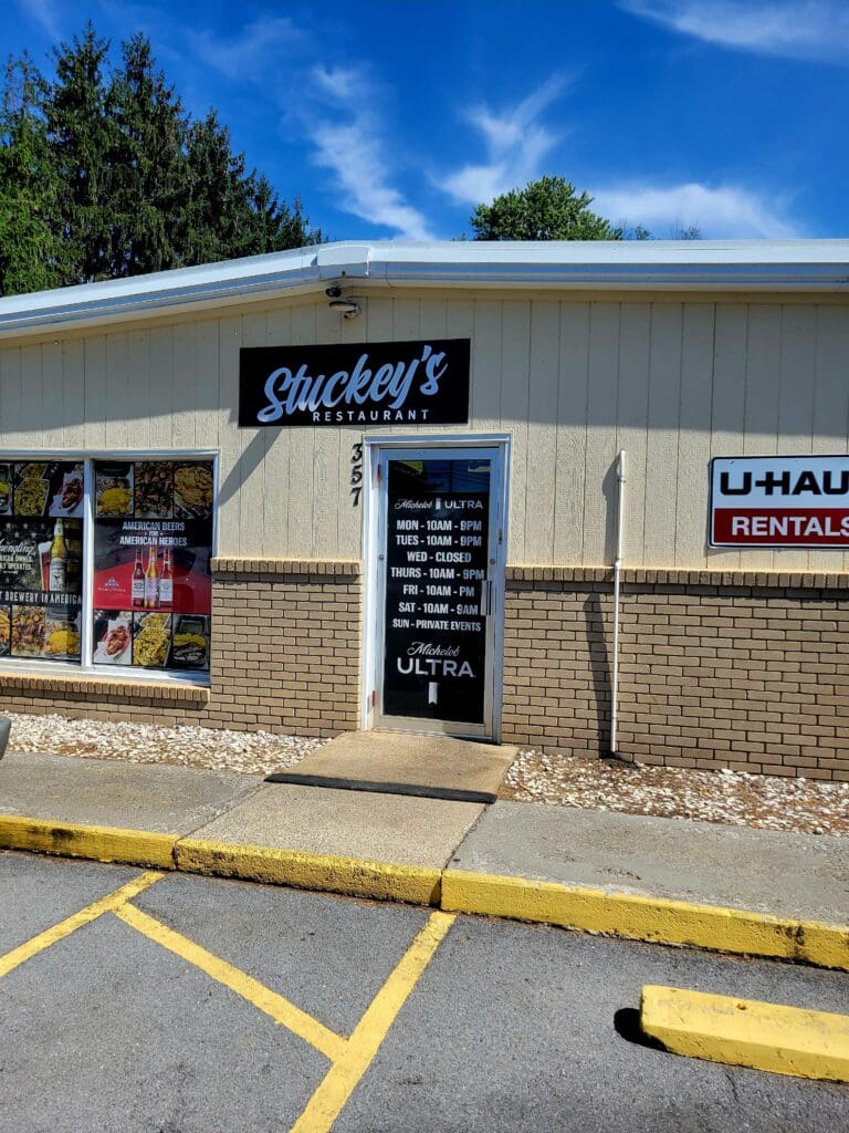 A brick storage facility storefront with Stockley's signage and U-Haul rental services, photographed during daytime with clear blue sky and yellow parking lot markings.