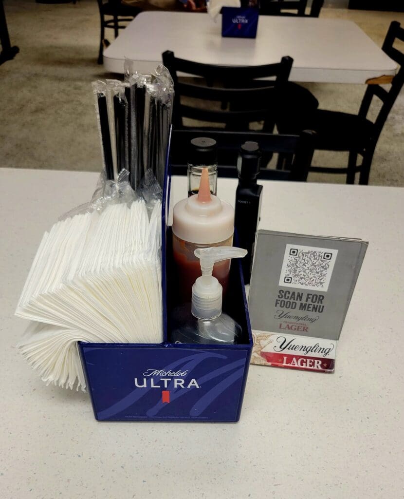 An overhead view of a workshop or presentation table displaying Michelob Ultra beer products, promotional materials, and papers arranged for an event or tasting.