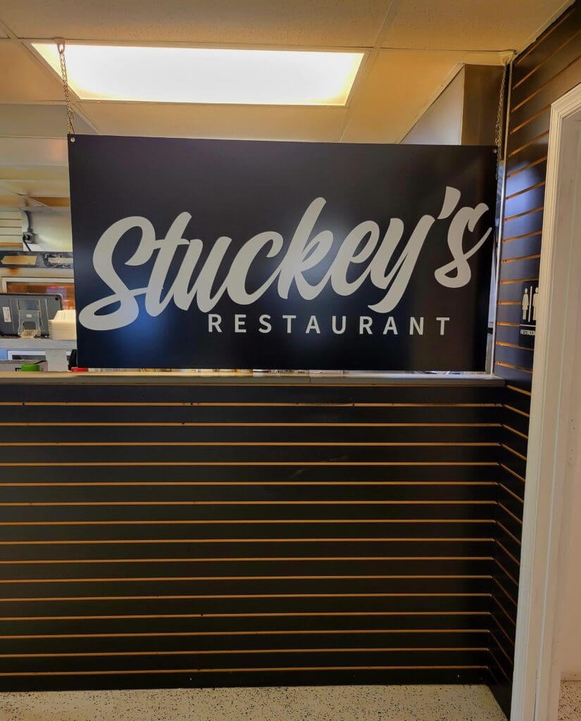 Stuckey's Restaurant vintage neon-style sign illuminated on a dark blue background inside an indoor venue or storefront.